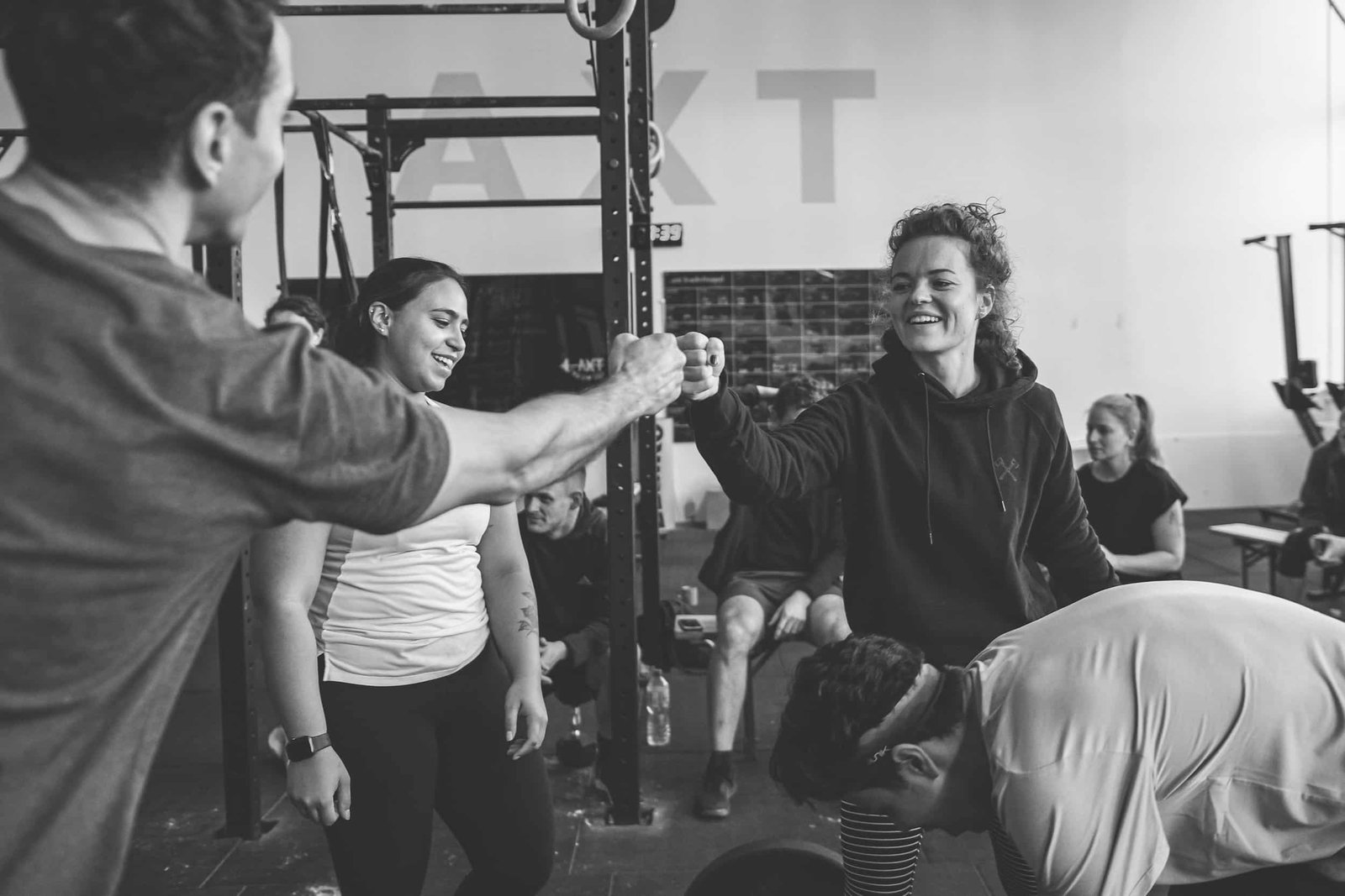 Faustgruß und Lachen nach dem Training in der AXT-Box in Berlin-Lichtenberg, im Hintergrund der AXT-Schriftzug am Rig